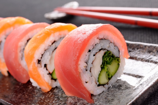 Rodillo de sushi de salmón con palillos de cerca