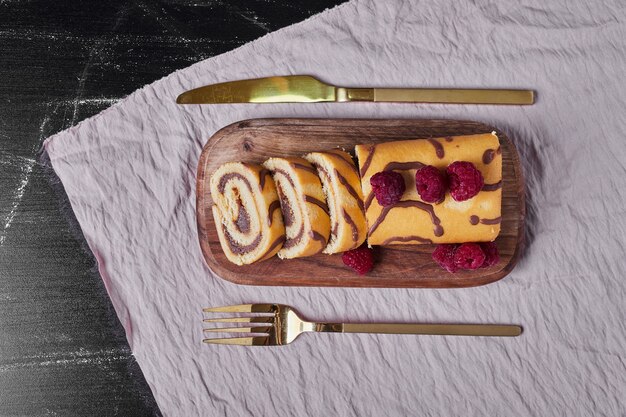 Rollcake con frutos rojos en una bandeja.