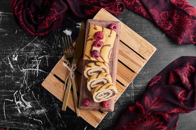 Rollcake con relleno de chocolate sobre una tabla de madera.