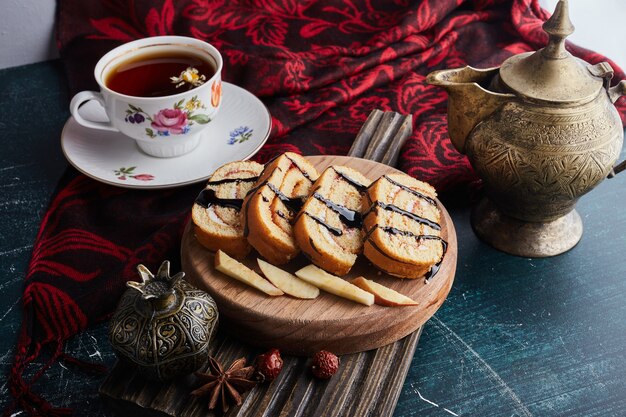 Rollcake en rodajas con una taza de té.