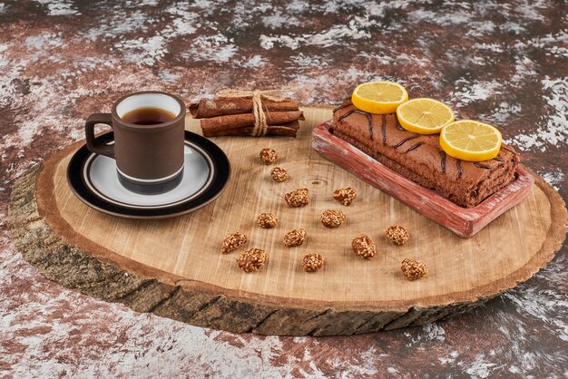 Rollcake y té en una tabla de madera.