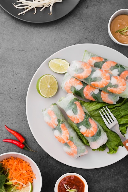 Rollitos de camarones en un plato con lima y salsa