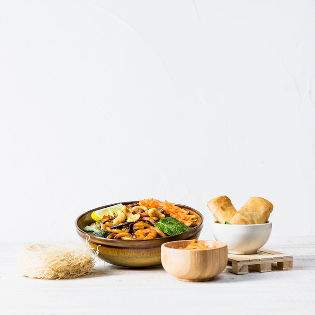 Rollitos de primavera un tazón de fideos tailandeses con camarones y fideos