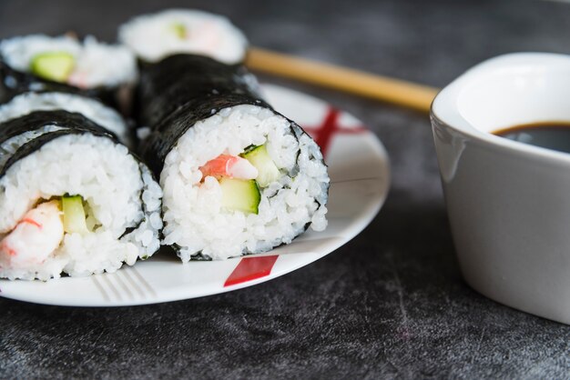 Rollitos de sushi, salsa de soja y palillos.