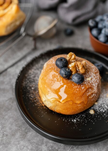 Rollo de canela sabroso de alto ángulo con frutas