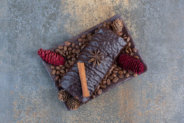 Rollo de chocolate con granos de café y piñas. Foto de alta calidad