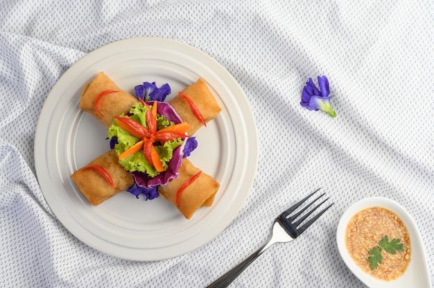 Rollo de huevo o Fried Spring Rolls en la comida tailandesa de la placa blanca. Vista superior.