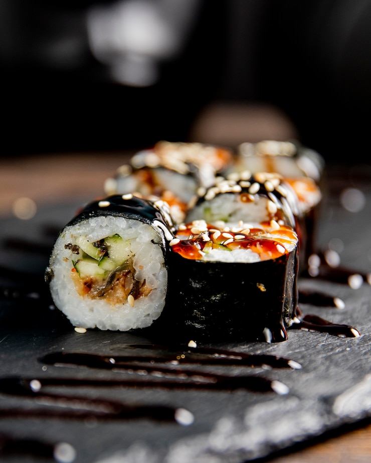 Foto gratuito rollo de maki con pepino servido con salsa y semillas de sésamo