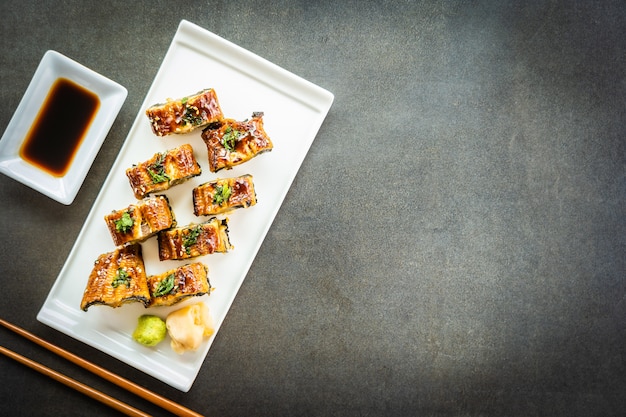 Rollo de maki de sushi de anguila o unagi a la parrilla con salsa dulce