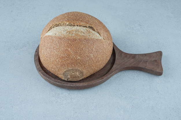 Rollo de pan de centeno sobre tabla de madera