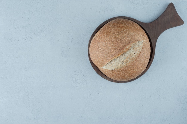 Rollo de pan de centeno sobre tabla de madera