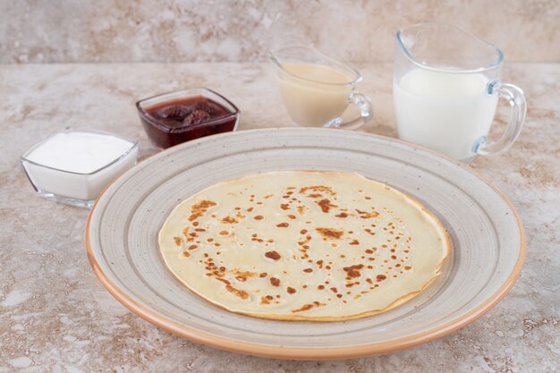 Rollo de panqueques con requesón y mermelada de fresa.