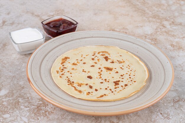 Rollo de panqueques con requesón y mermelada de fresa.