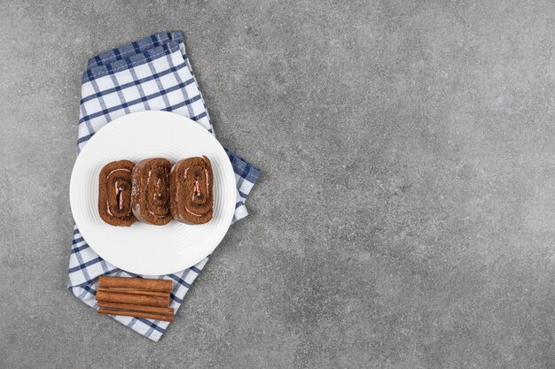 Rollo de pastel de chocolate en un plato blanco con canela