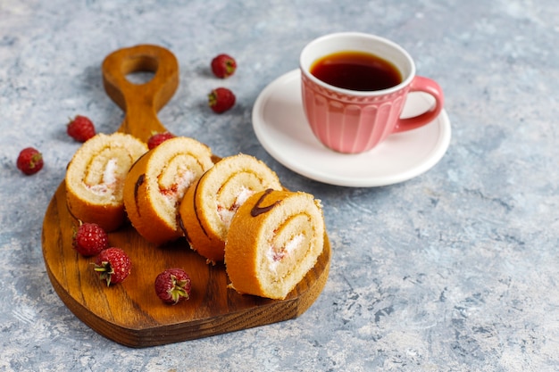 Rollo de pastel de frambuesa con frutos rojos frescos.