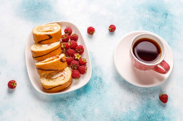 Rollo de pastel de frambuesa con frutos rojos frescos.