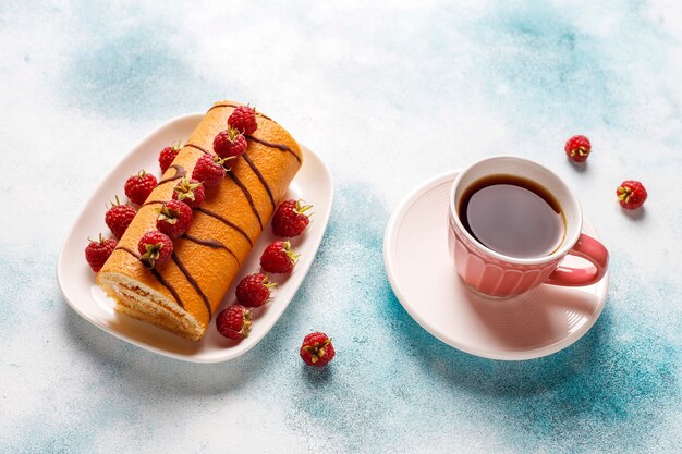 Rollo de pastel de frambuesa con frutos rojos frescos.