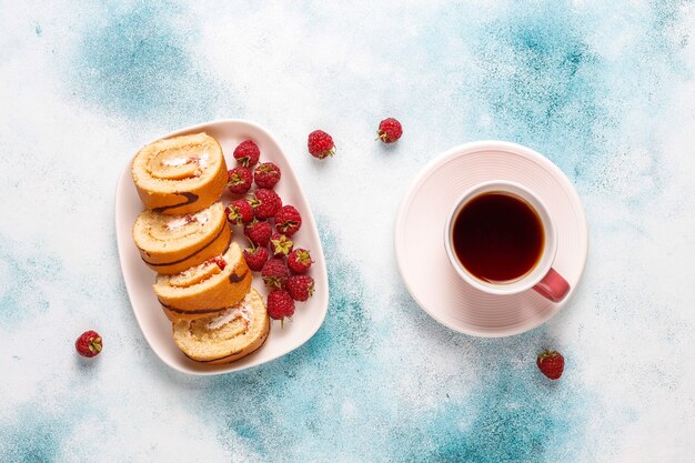 Rollo de pastel de frambuesa con frutos rojos frescos.