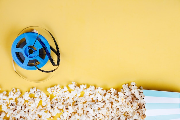 Rollo de película cerca de línea de palomitas de maíz de caja