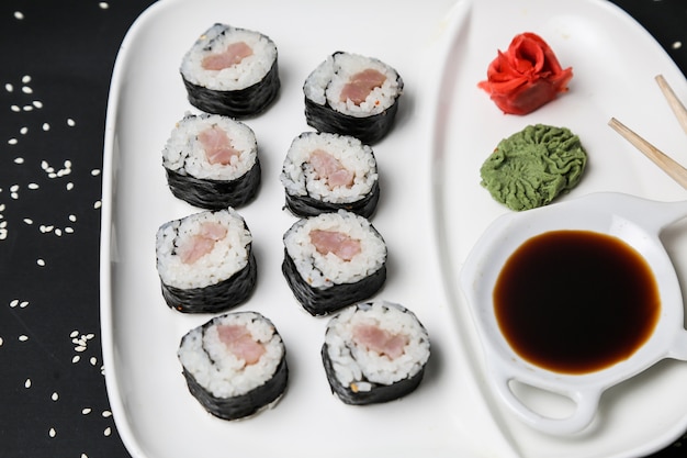 Foto gratuita rollo de salmón arroz jengibre wasabi sésamo vista lateral