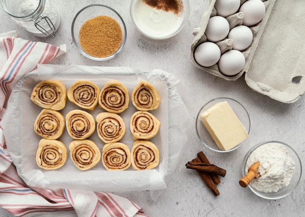 Foto gratuita rollos de canela y huevos planos laicos