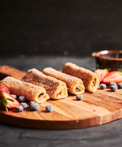 Rollos de chocolate sabroso en tablero de madera