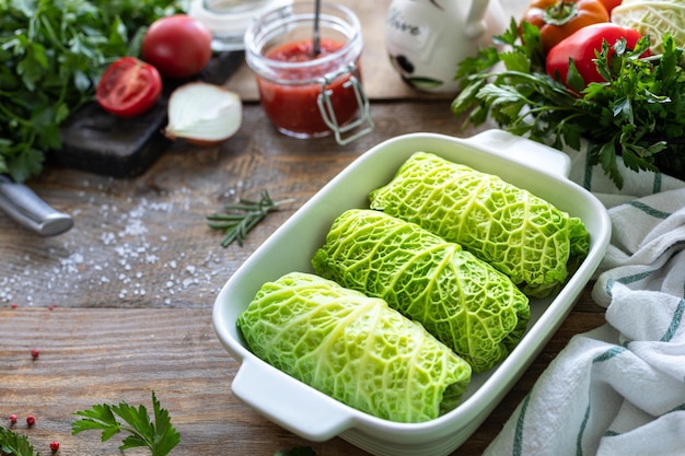 Foto gratuita rollos de col de saboya rellenos de arroz con carne y verduras en una mesa rústica