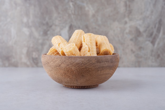 Rollos de galleta en un recipiente sobre la mesa de mármol.