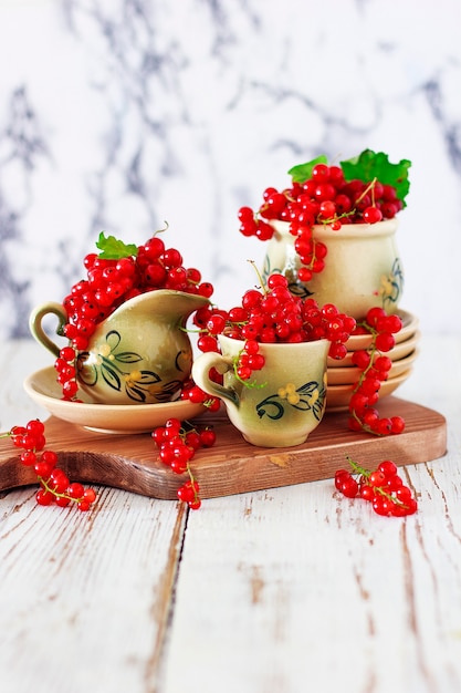 Rollos de galleta de requesón con grosellas rojas en plato de cerámica con té o café de cerámica vintage, hora del té, desayuno, dulces de verano