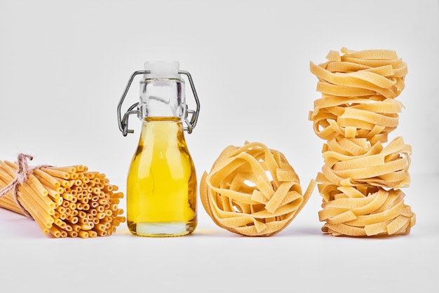 Foto gratuita rollos de pasta con una botella de aceite.