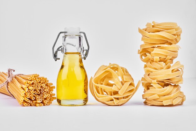 Rollos de pasta con una botella de aceite.