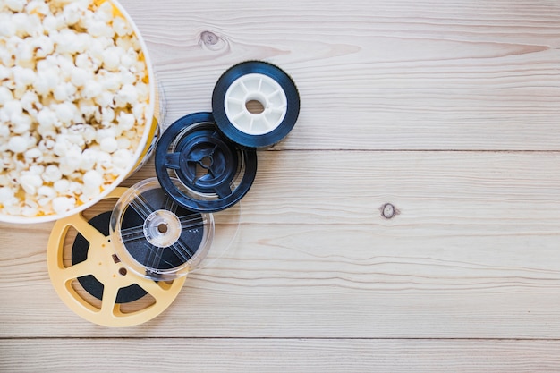 Rollos de película y cubo sobre palomitas de maíz