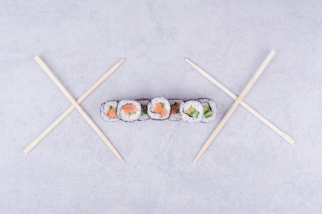 Foto gratuita rollos de sake maki con salmón y aguacate en gris.