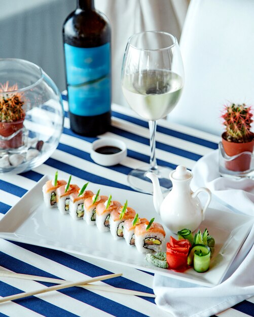 Rollos de sushi con copa de vino blanco