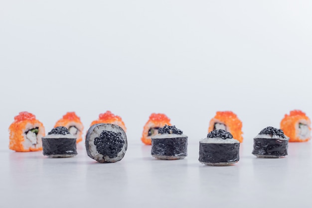 Foto gratuita rollos de sushi de maki y california sobre fondo blanco.