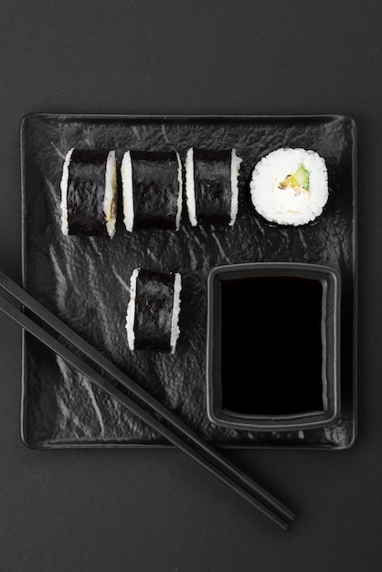 Rollos de sushi con palillos en placa