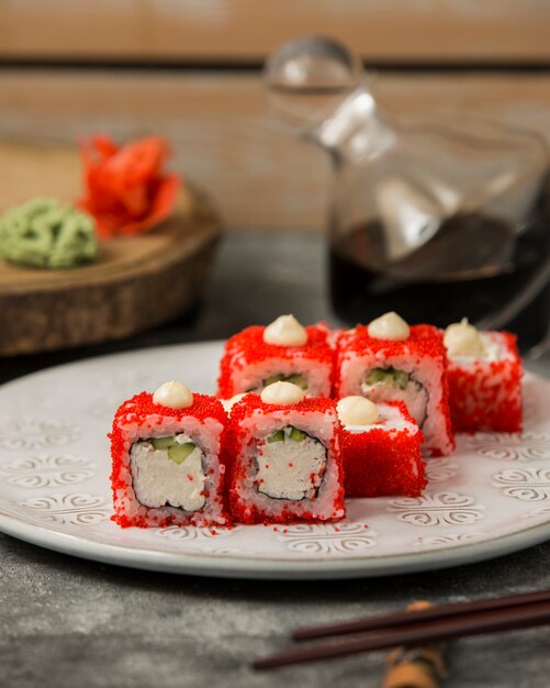 Rollos de sushi con palitos de cangrejo y pepino cubiertos con tobiko rojo