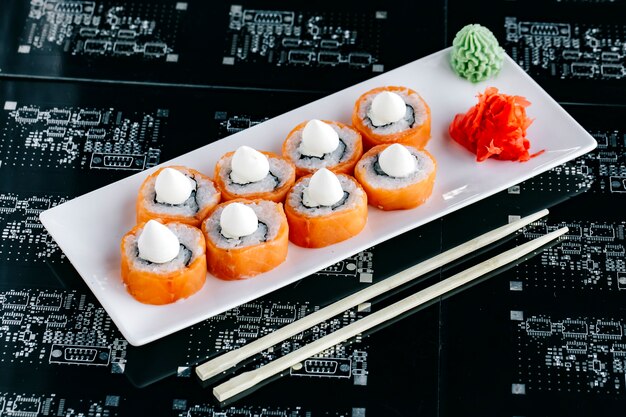 Rollos de sushi de salmón cubiertos con mayonesa japonesa