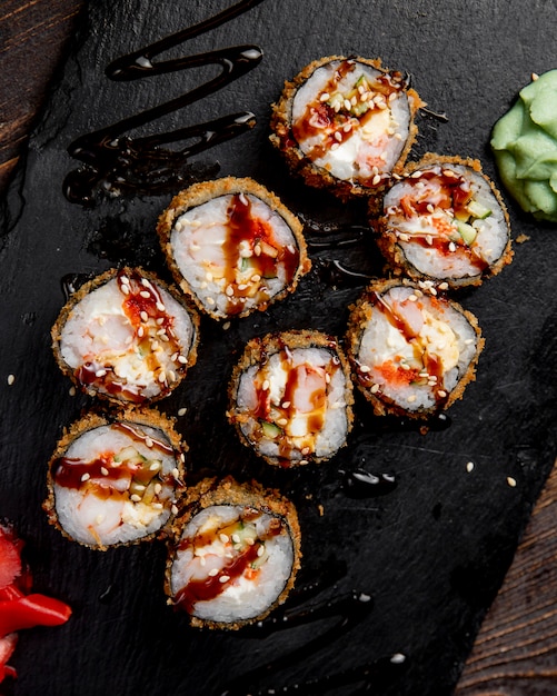rollos de sushi servidos con salsa de wasabi y semillas de sésamo