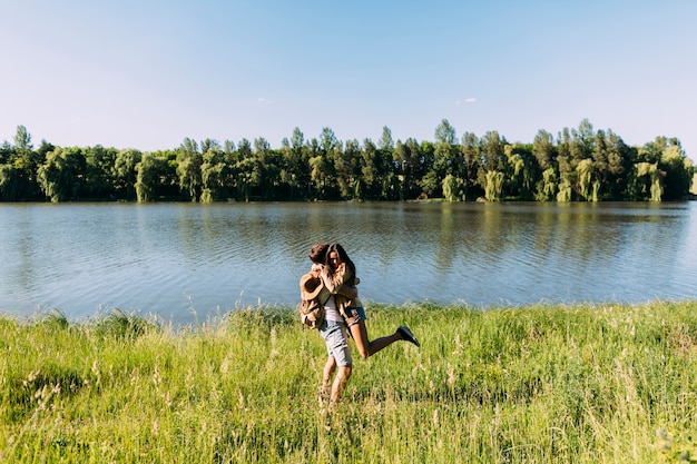 Romántica pareja joven disfrutando cerca del hermoso lago tranquilo