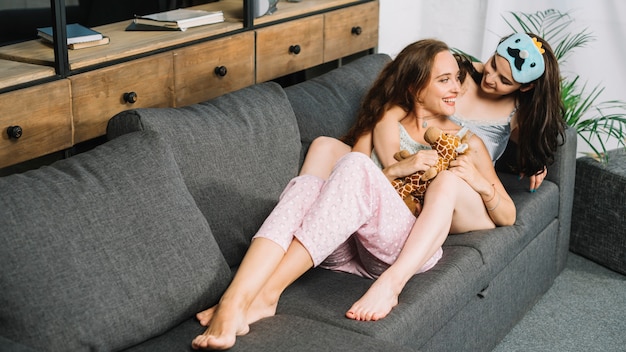 Foto gratuita romántica pareja de lesbianas apoyándose en el sofá en casa