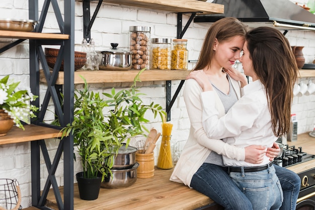 Romántica pareja de lesbianas jóvenes en la cocina.