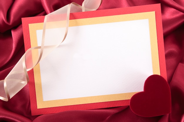 Romántica tarjeta de san valentín sobre seda roja