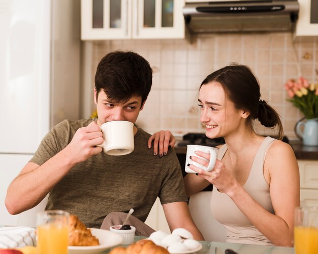 Foto gratuita romántico joven hombre y mujer desayunando