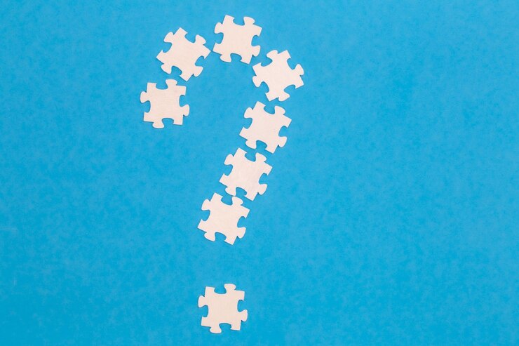 Foto gratuito rompecabezas blancos en forma de signo de interrogación sobre un fondo azul plano