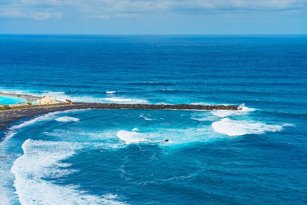 Rompeolas de playa con arena negra. Playa de Martianez, Puerto de la Cruz, Tenerife, España