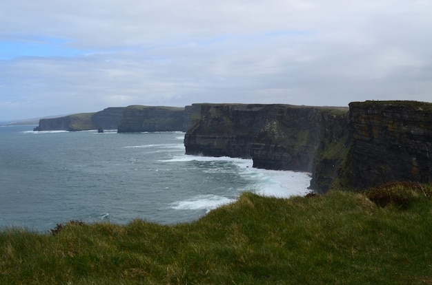 Foto gratuita rompiendo las olas de la bahía de galway en los acantilados de moher ubicado en irlanda