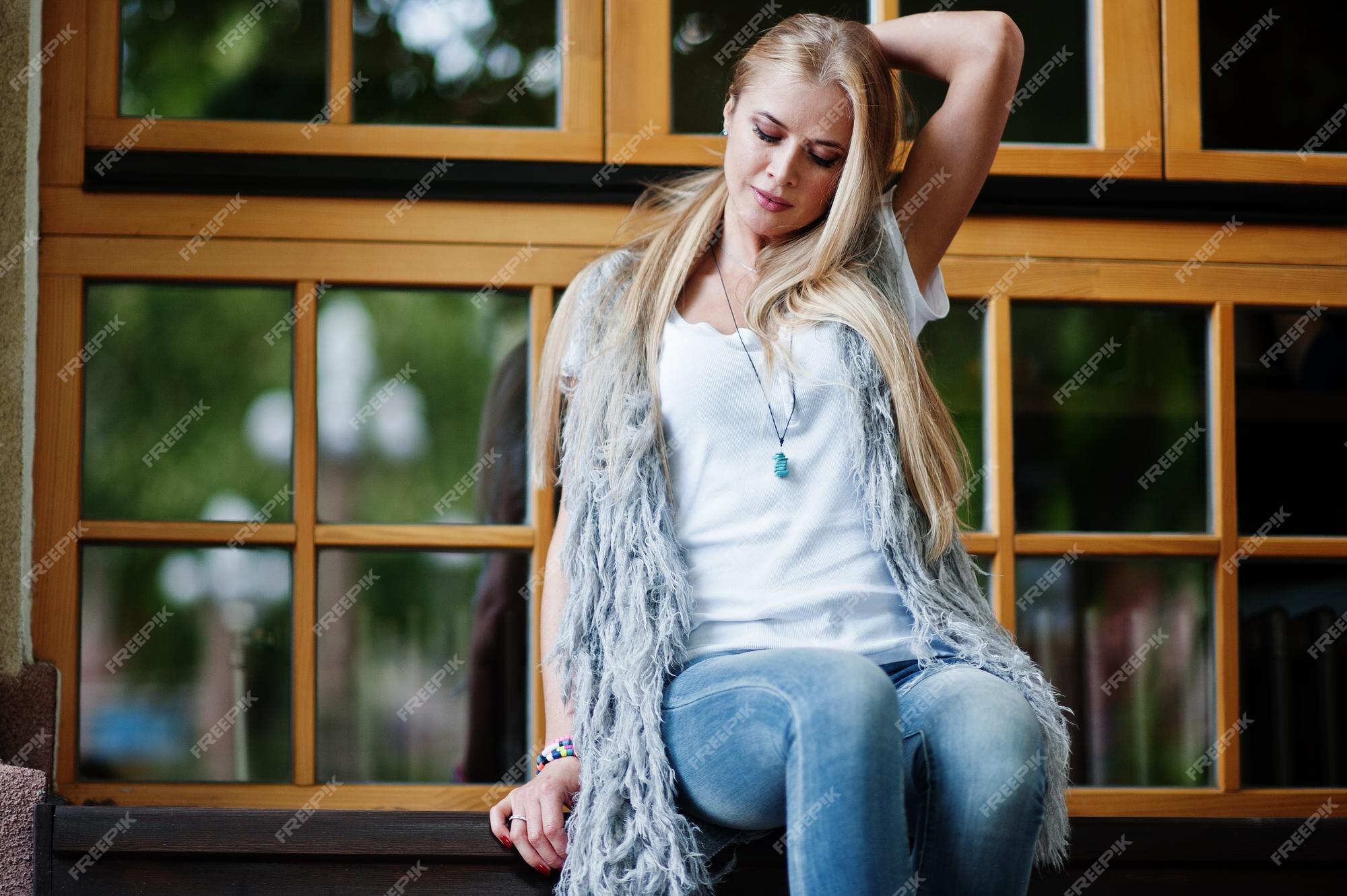 Ropa de rubia elegante en jeans y chica mangas con camisa blanca contra ventanas en la calle retrato de modelo urbano de moda | Foto Gratis