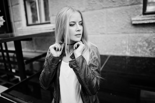 Ropa de mujer rubia con estilo en gargantilla de jeans y chaqueta de cuero en la calle Retrato de modelo urbano de moda