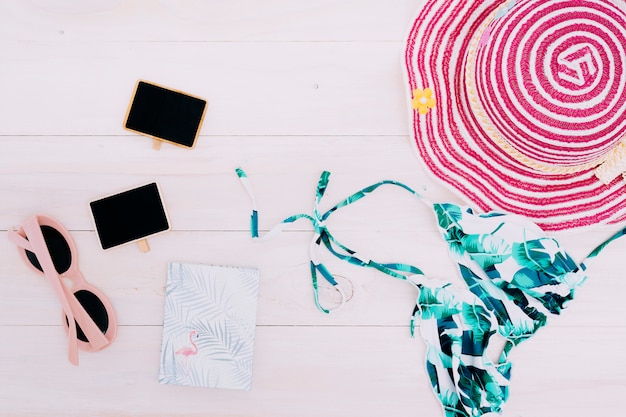 Foto gratuita ropa de playa y accesorios sobre fondo claro.